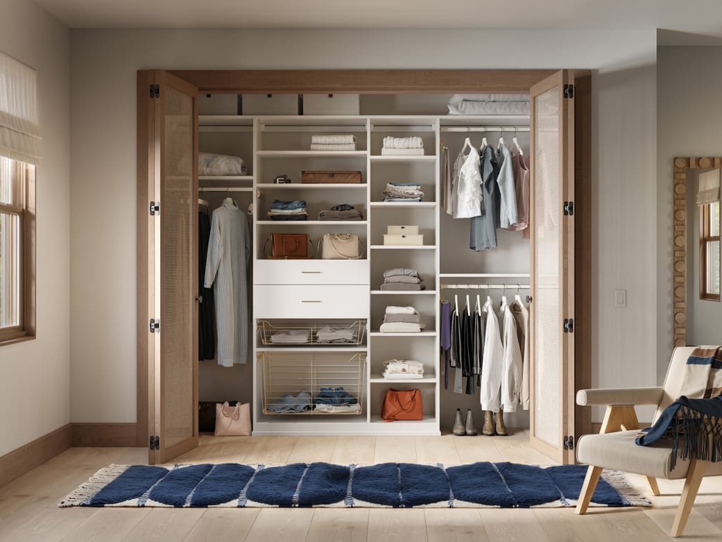 Designed with custom drawers and cubbies, to-floor shelving, and open shelving by California Closets