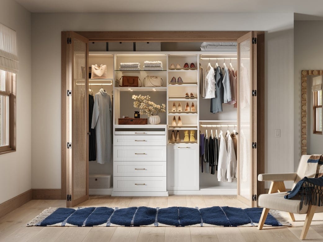 Reach in closet with shoe racks, built in drawers and customized lighting by California Closets